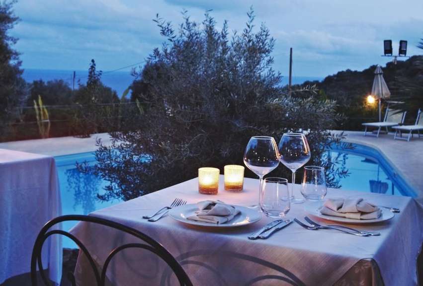 Ein Tisch mit Tellern und Gläsern in der Nähe eines Pools