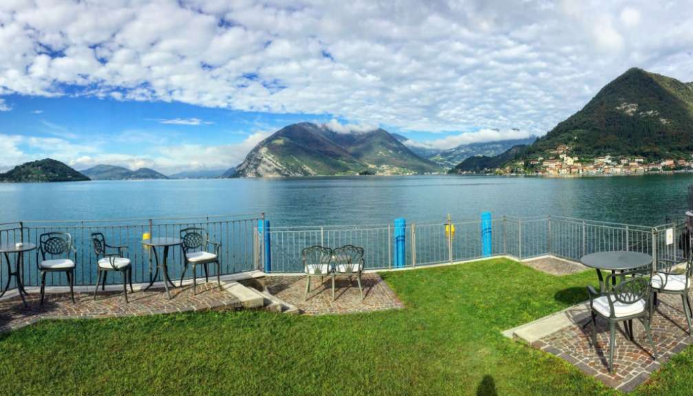 Tische und Stühle auf einem Balkon mit Blick auf einen See