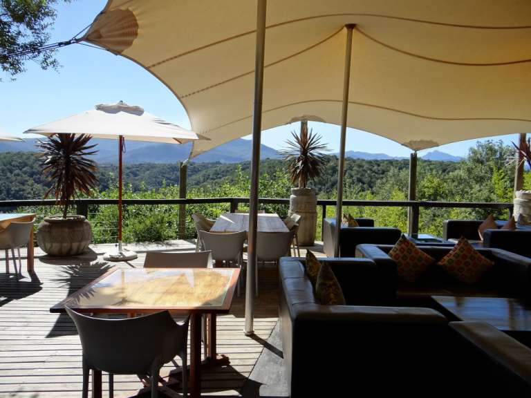Ein Tisch und Stühle auf einem Deck mit Blick auf die Berge