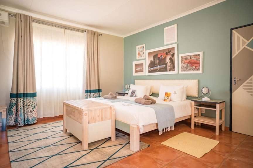Ein Schlafzimmer mit zwei Betten und Bildern an der Wand