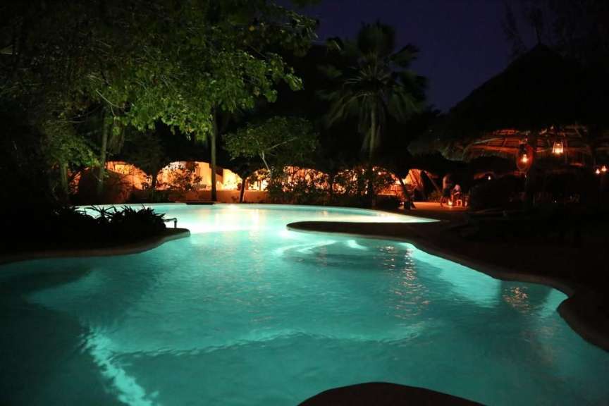 Ein großer Swimmingpool leuchtet in der Nacht