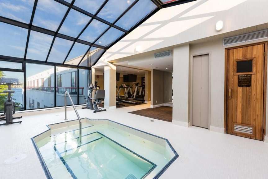 Ein Fitnessstudio mit einem Whirlpool und einer Sauna