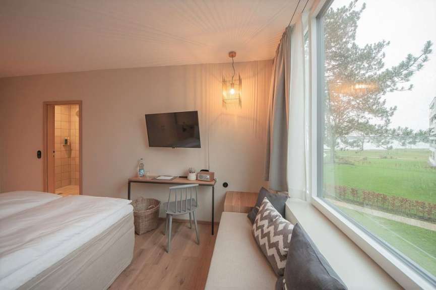 Ein Zimmer mit einem Bett, einem Schreibtisch und einem Fernseher