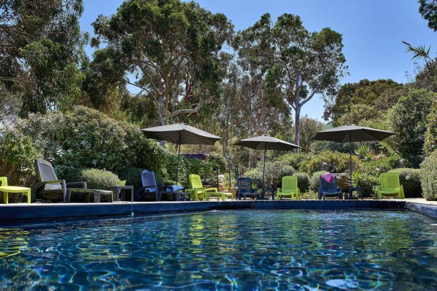 Ein Swimmingpool mit Stühlen und Sonnenschirmen umgeben