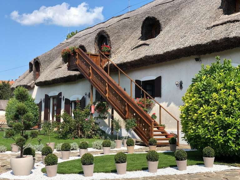 Ein Haus mit Strohdach und einer Holztreppe
