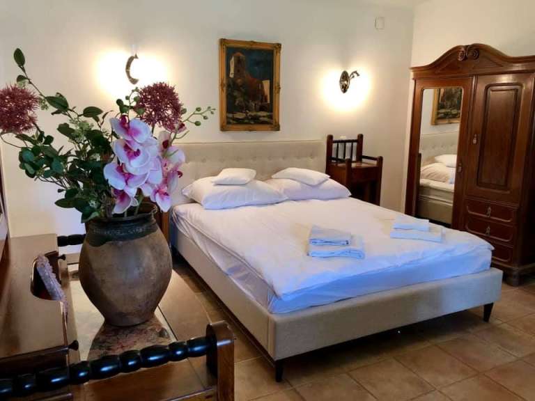 Ein Schlafzimmer mit einem Bett und einer Vase mit Blumen darauf