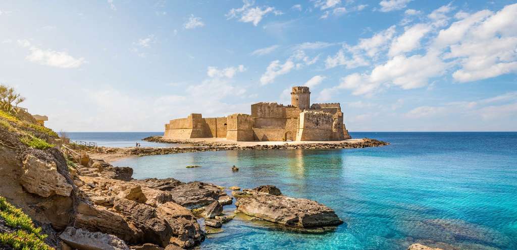 Ein großes Schloss sitzt auf einer kleinen Insel im Ozean