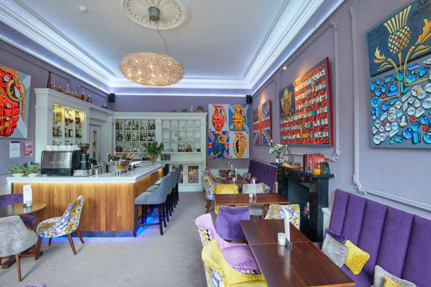 Ein Restaurant mit lila Stühlen und Tischen und einer Bar