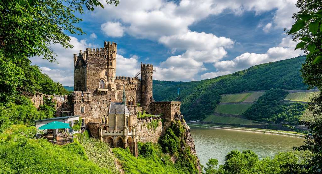 Ein altes Schloss auf einem Hügel mit Blick auf einen Fluss