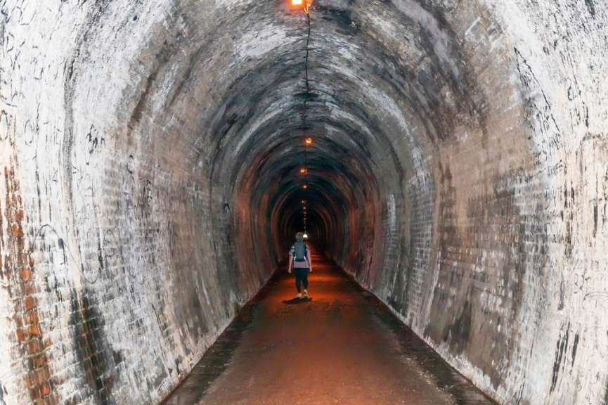 Eine Person geht in einem Tunnel mit Graffiti an den Wänden