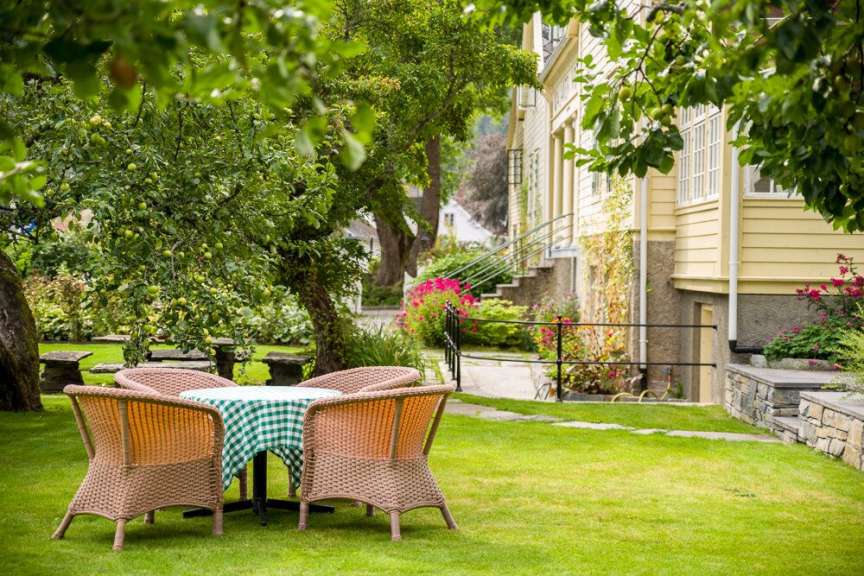 Ein Tisch und Stühle auf einem grünen Rasen vor einem Haus