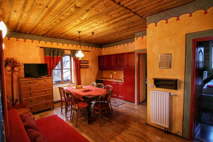 Ein Wohnzimmer mit einem Tisch und Stühlen und einem Fernseher