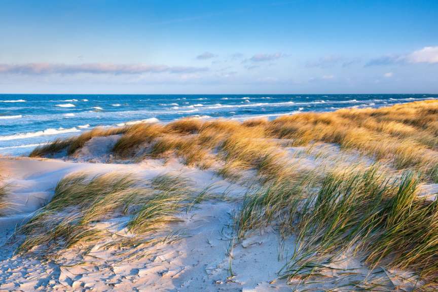 Eine Sanddüne führt zum Ozean