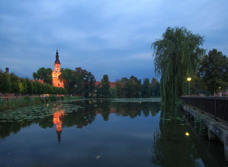 Eine Kirche spiegelt sich in einem Teich