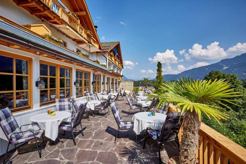 Tische und Stühle auf einem Balkon mit Blick auf die Berge