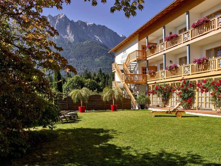 Ein Hotel mit einem großen Rasen vorne und einem Balkon
