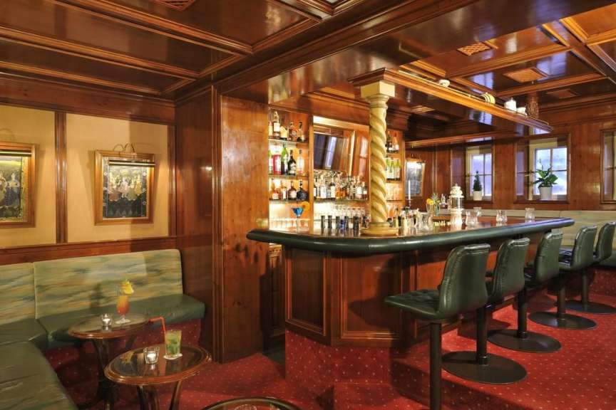 Eine Bar mit vielen Getränken und Stühlen