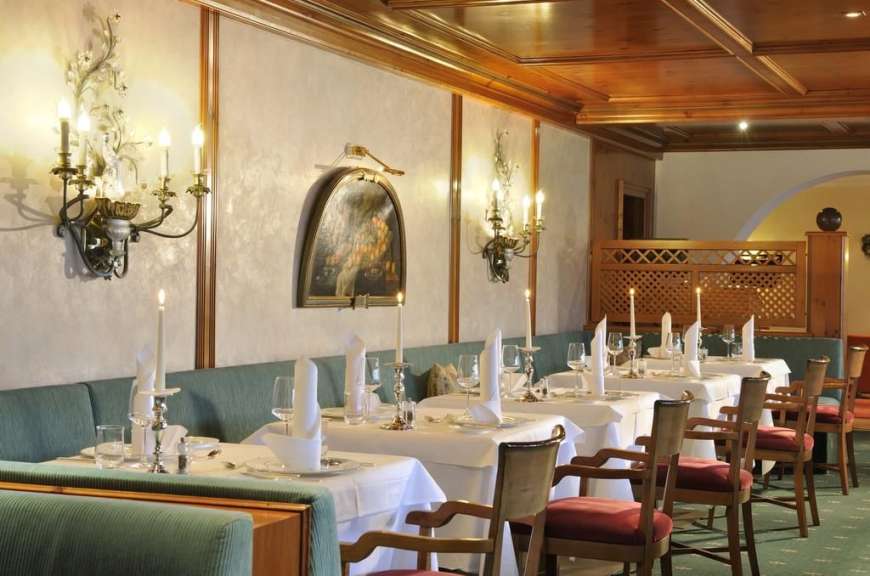 Tische und Stühle in einem Restaurant mit Kerzen und einem Gemälde an der Wand