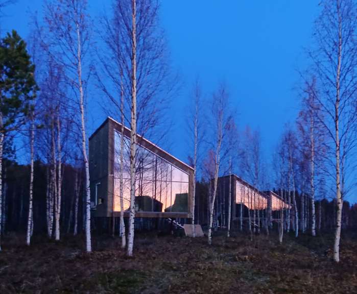 Ein Gebäude mit vielen Fenstern in einem Wald
