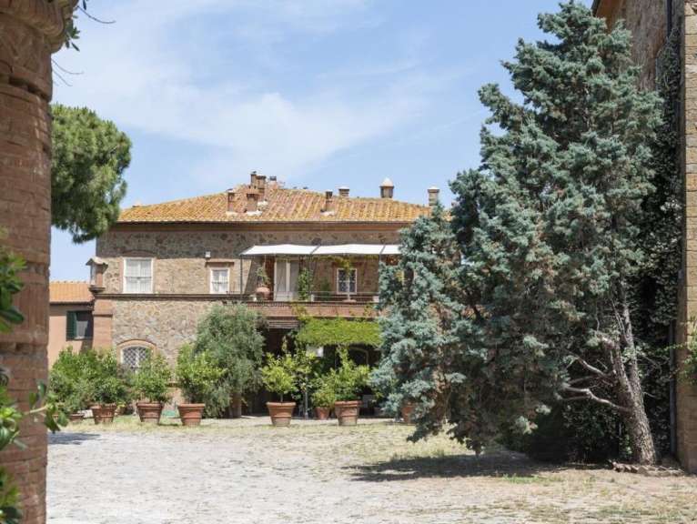 Ein großes Steingebäude mit einem Balkon und vielen Pflanzen in Töpfen