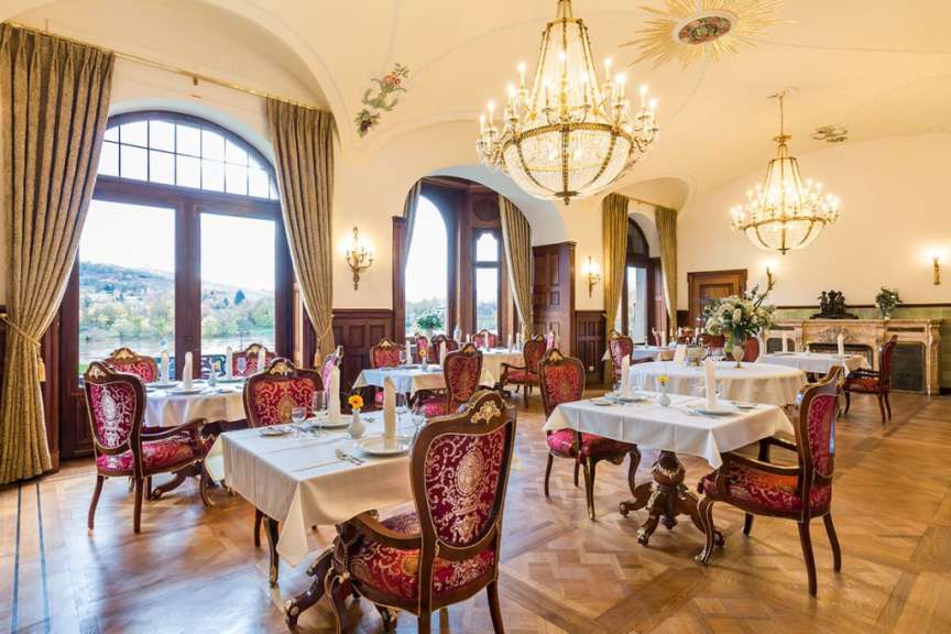 Ein Esszimmer mit vielen Tischen und Stühlen
