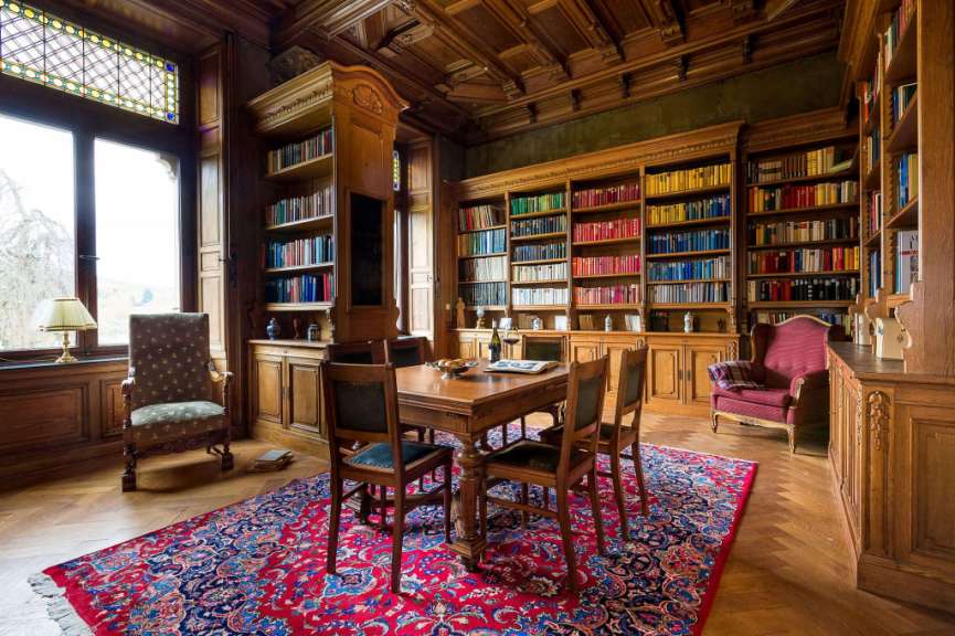 Ein Wohnzimmer mit einem Tisch und Stühlen und Bücherregalen