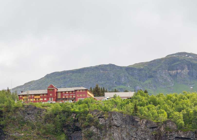 Ein großes rotes Hotel steht auf einem Berghang