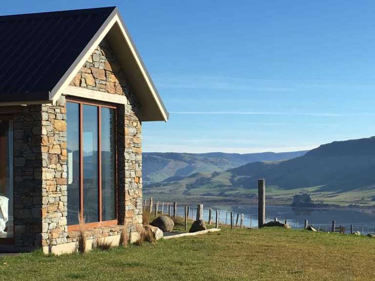 Ein Haus mit Blick auf einen See mit Bergen im Hintergrund