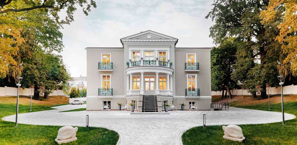 Ein großes weißes Haus mit vielen Fenstern und Balkonen
