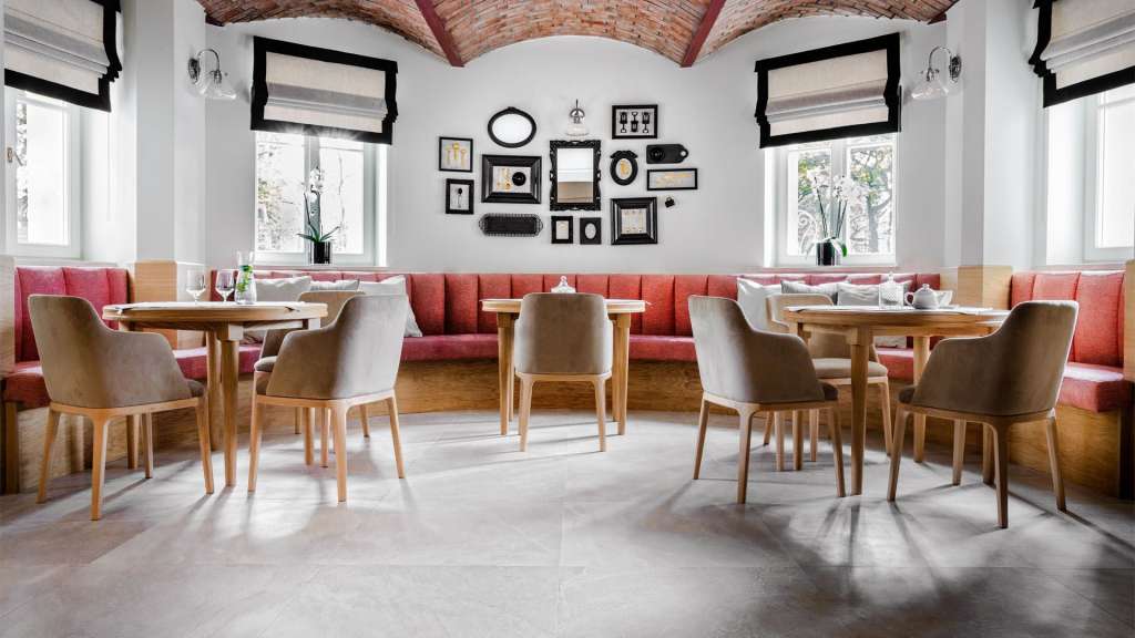 Ein Esszimmer mit Tischen und Stühlen und Bildern an der Wand