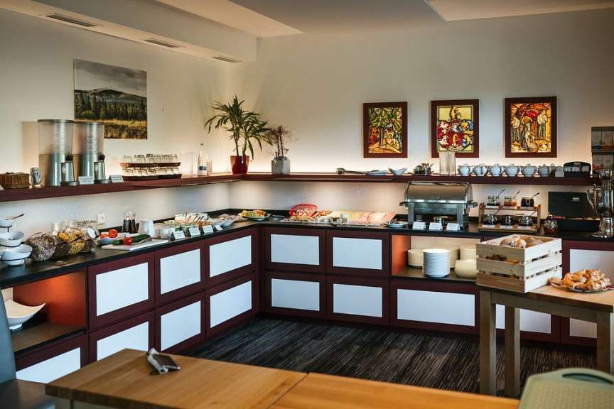 Auf diesem Bild ist ein Buffet in einem Hotel oder Restaurant zu sehen, das mit verschiedenen Speisen und Getränken wie Obst, Müsli, Brötchen und Kaffee ausgestattet ist.