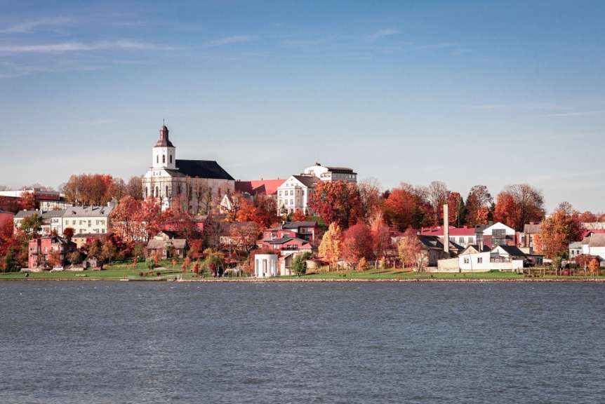 Eine Stadt mit einer Kirche und einem See im Vordergrund