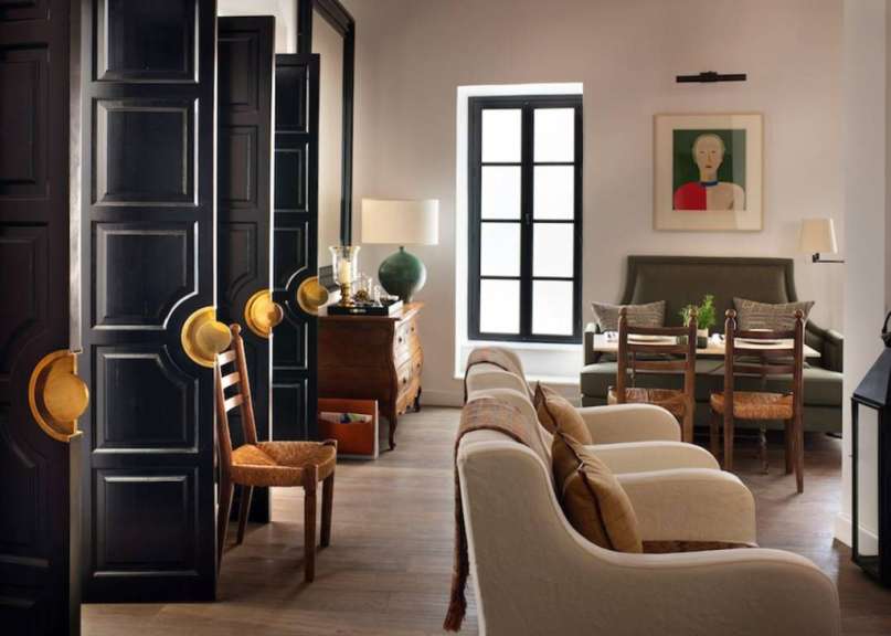 Ein Wohnzimmer mit schwarzen Türen und einem Gemälde an der Wand