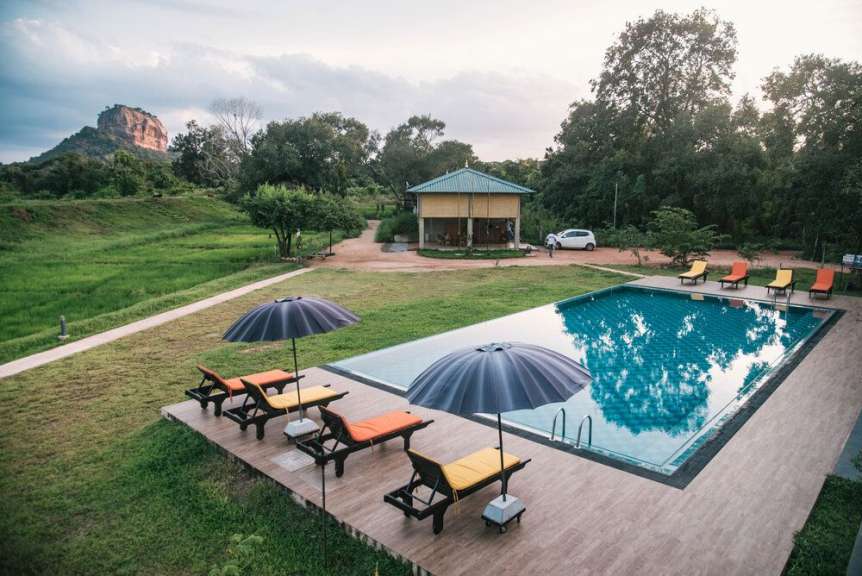 Ein großer Pool mit Liegestühlen und Sonnenschirmen davor