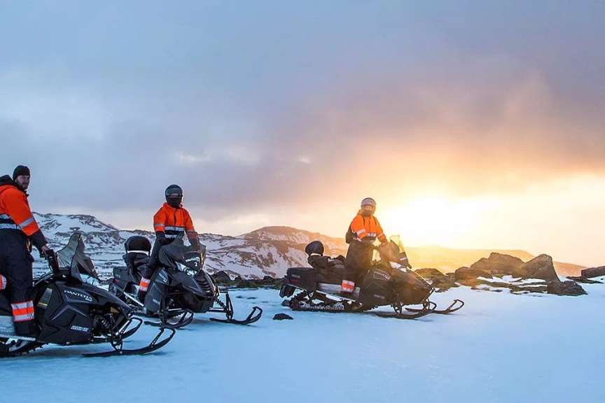 Eine Gruppe von Menschen steht neben einem Schneemobil mit der Aufschrift polaris