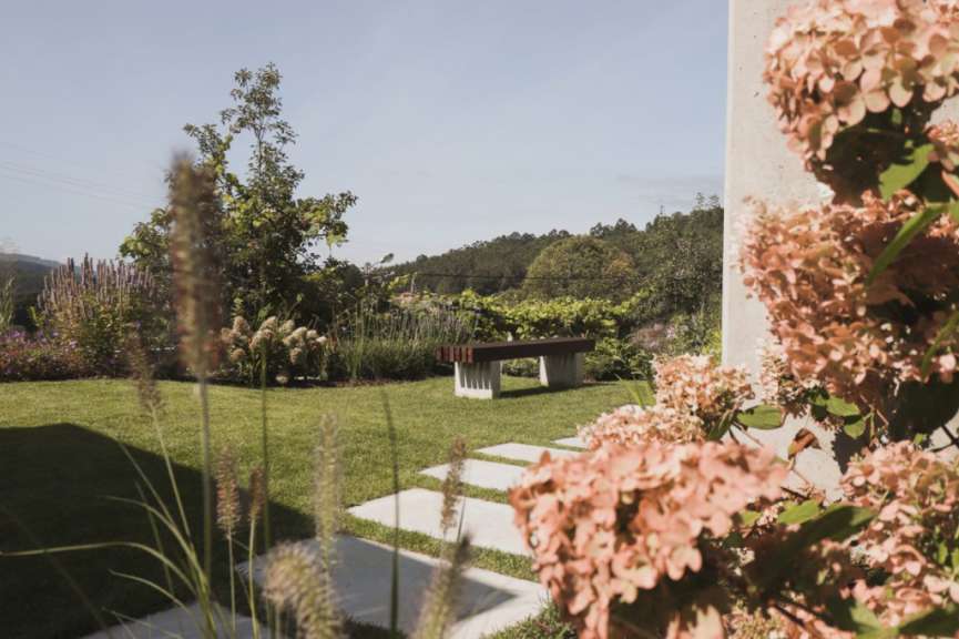 Ein Garten mit einer Bank und Blumen im Vordergrund