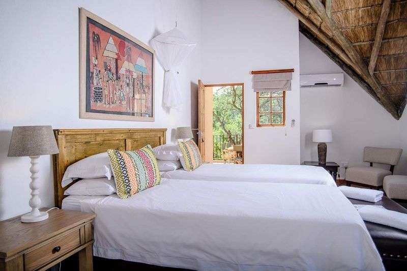 Ein Schlafzimmer mit zwei Betten und einem Gemälde an der Wand
