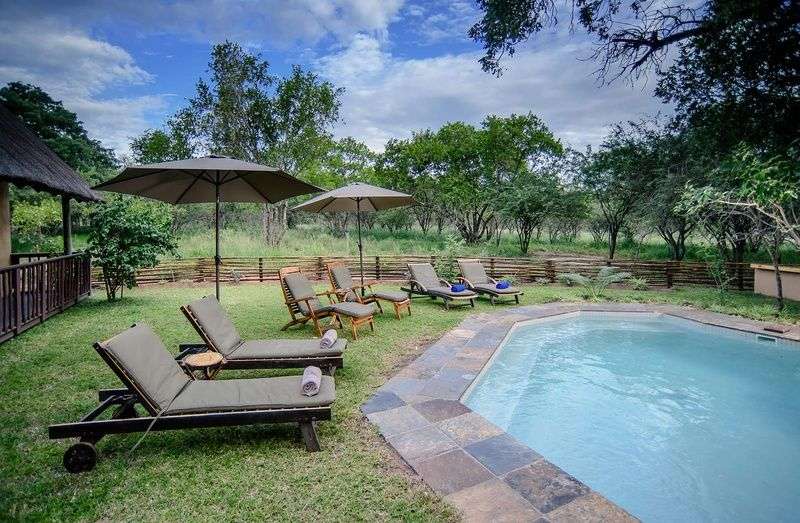 Ein Pool mit Liegestühlen und Sonnenschirmen umgeben