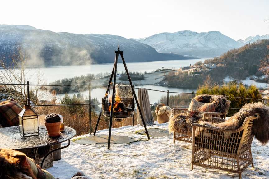 Ein Tisch und Stühle im Schnee mit einem Feuer im Hintergrund