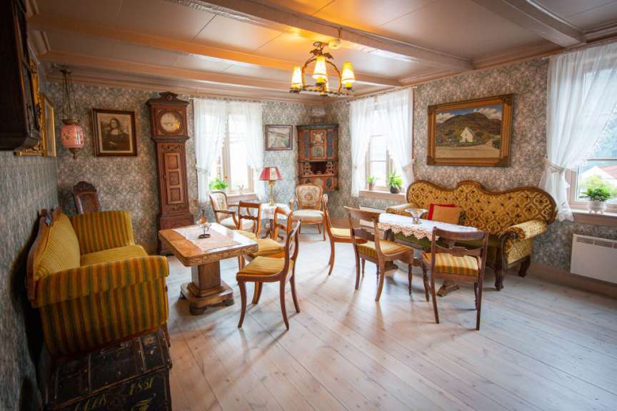 Ein Wohnzimmer mit einem Tisch und Stühlen und einer Uhr
