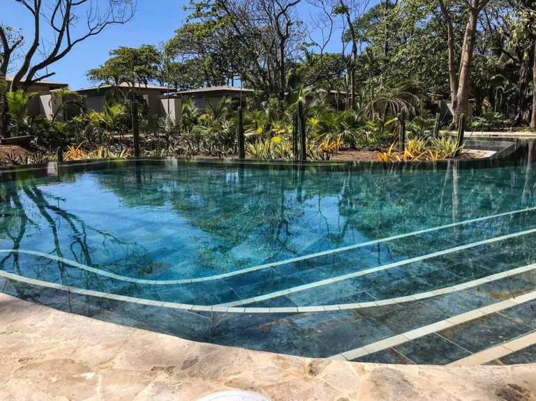 Ein schöner Pool mit klarem Wasser und einer angrenzenden üppigen Vegetation.