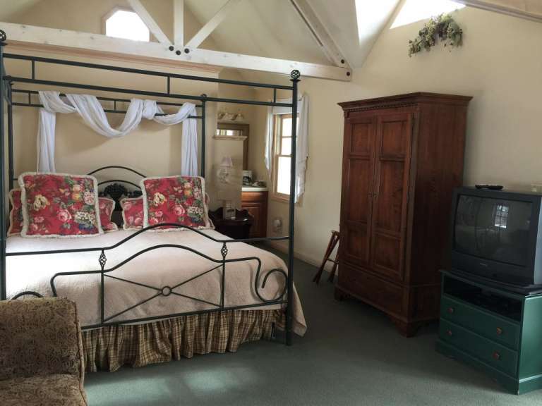 Ein Schlafzimmer mit einem Himmelbett und einem Fernseher
