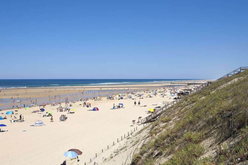 Ein Strand mit vielen Menschen und vielen Sonnenschirmen
