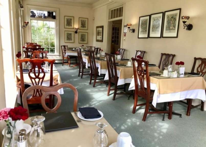 Ein Esszimmer mit vielen Tischen und Stühlen