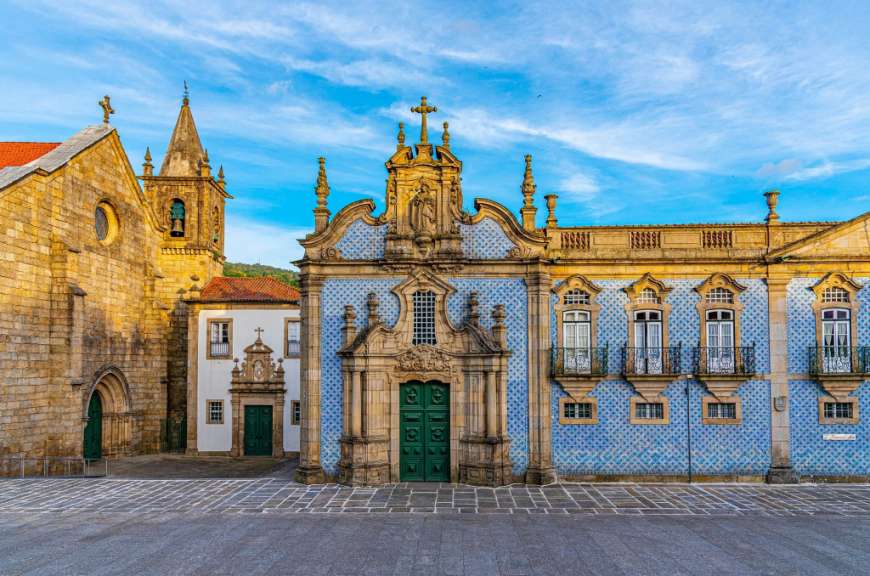Ein blau-weißes Gebäude mit einer Statue auf dem Dach