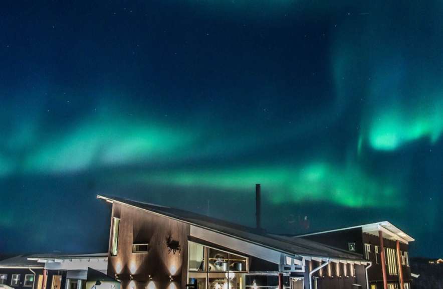 Das Nordlicht scheint über einem großen Gebäude