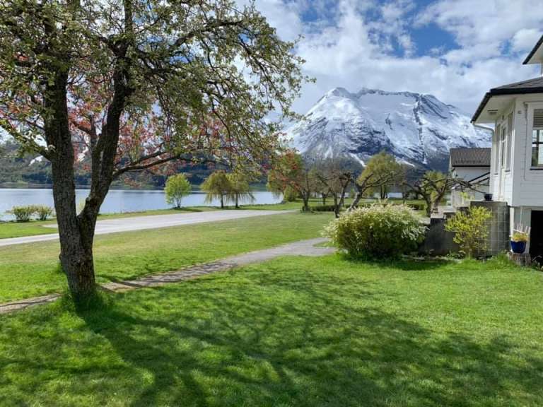 Ein schneebedeckter Berg sitzt hinter einem Haus