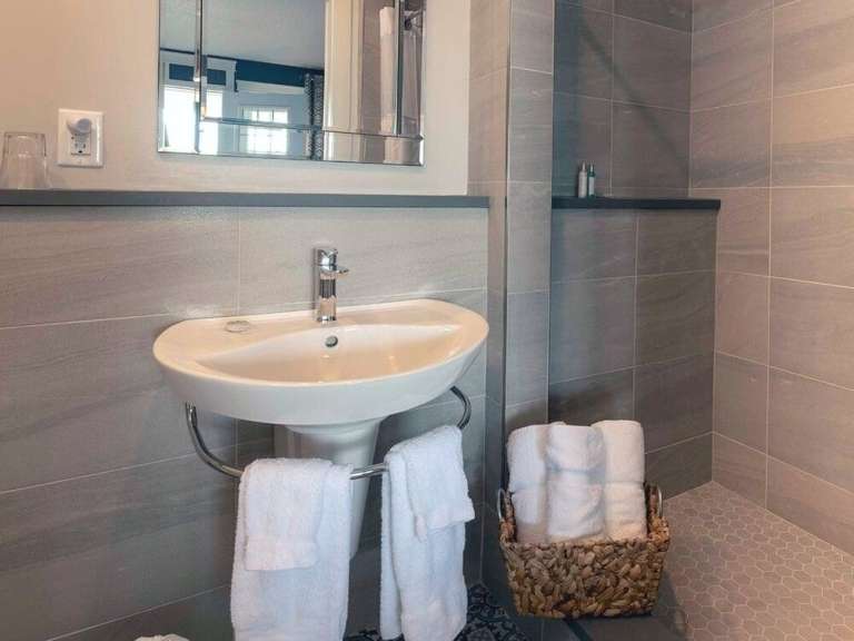 Ein Badezimmer mit Waschbecken und Handtuchhaltern