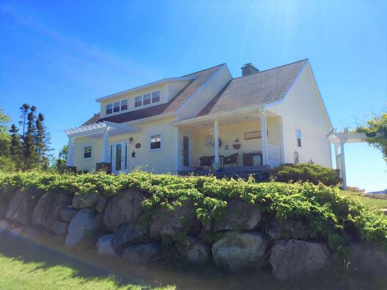 Ein weißes Haus mit einer Veranda und einer Pergola