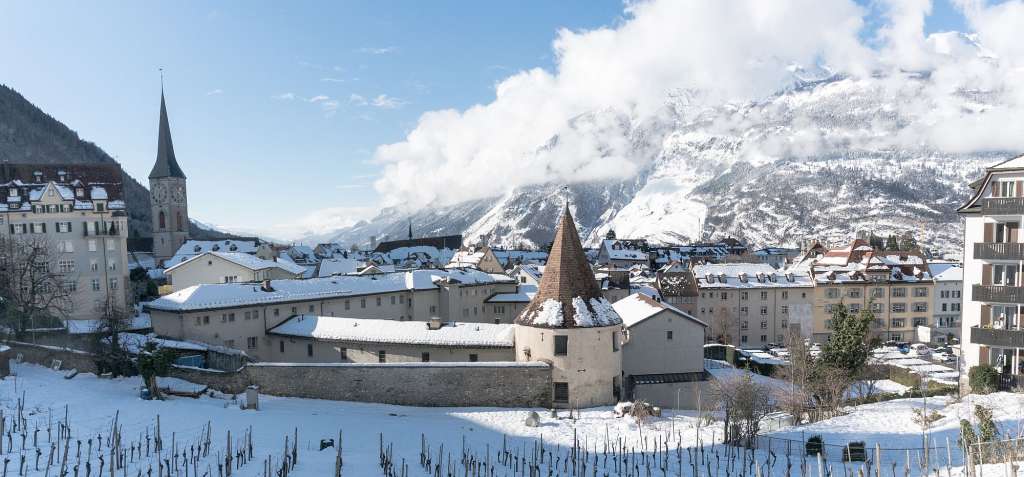 Eine Stadt mit schneebedeckten Gebäuden und Bergen im Hintergrund